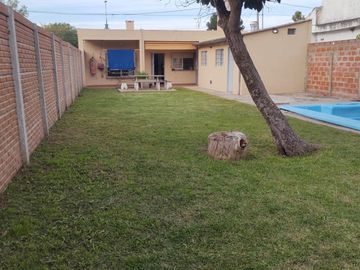 EXCELENTE PROPIEDAD DE CUATRO AMBIENTES CON GARAGE CUBIERTO PATIO JARDINFONDO LIBRE Y PISCINA