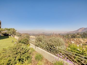 Departamento con vista panorámica a Santiago, jardín y piscina privada