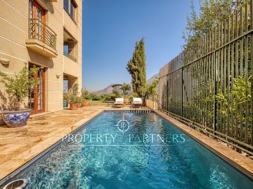 Departamento con vista panorámica a Santiago, jardín y piscina privada
