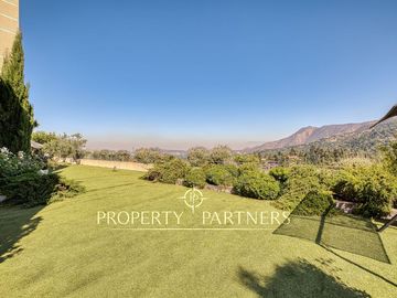 Departamento con vista panorámica a Santiago, jardín y piscina privada