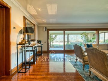 Departamento con vista panorámica a Santiago, jardín y piscina privada