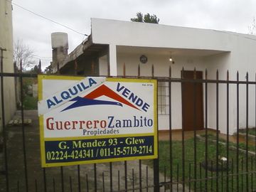 Casa americana al frente con otras construcciones en su fondo