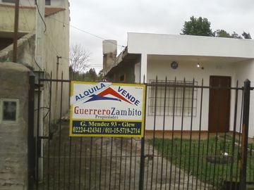 Casa americana al frente con otras construcciones en su fondo