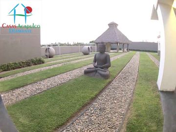 Departamento en renta vacacional, terraza con vista a las albercas y áreas comunes