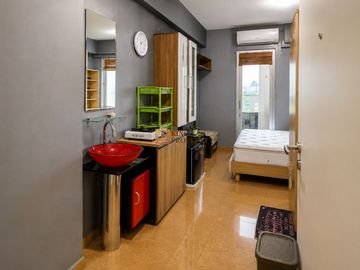 Disewakan Studio Green Bay Pluit – Modern Bedroom Studio with Red Vanity  Pool View Dekat Baywalk Mall Jakarta Utara