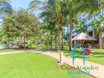 Departamento en renta vacacional. Terraza con vista a las albercas, jardines y parcial al mar