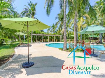 Departamento en renta vacacional. Terraza con vista a las albercas, jardines y parcial al mar