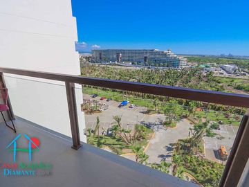 Departamento en renta vacacional. Terraza con vista a las albercas, jardines y parcial al mar