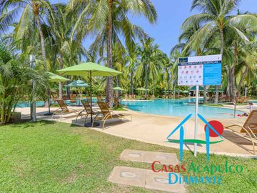 Departamento en renta vacacional. Terraza con vista a las albercas, jardines y parcial al mar