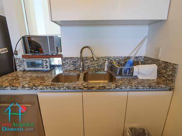 Departamento en renta vacacional. Terraza con vista a las albercas, jardines y parcial al mar