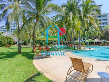 Departamento en renta vacacional. Terraza con vista a las albercas, jardines y parcial al mar