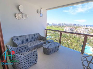 Departamento en renta vacacional. Terraza con vista a las albercas, jardines y parcial al mar