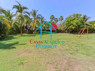 Departamento en renta vacacional. Terraza con vista a las albercas, jardines y parcial al mar