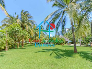 Departamento en renta vacacional. Terraza con vista a las albercas, jardines y parcial al mar
