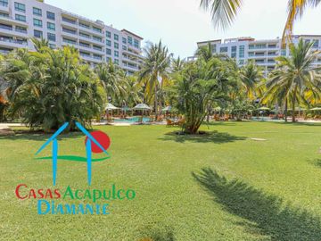 Departamento en renta vacacional. Terraza con vista a las albercas, jardines y parcial al mar