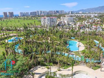 Departamento en renta vacacional. Terraza con vista a las albercas, jardines y parcial al mar