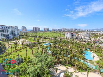 Departamento en renta vacacional. Terraza con vista a las albercas, jardines y parcial al mar