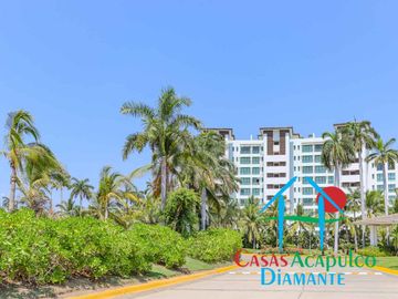 Departamento en renta vacacional. Terraza con vista a las albercas, jardines y parcial al mar